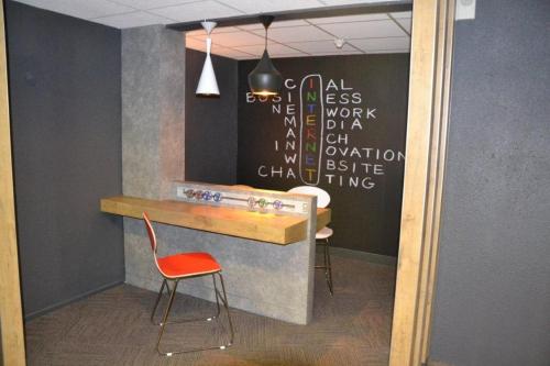 a bar with a chair and a table in a room at ibis Bordeaux Lac in Bordeaux