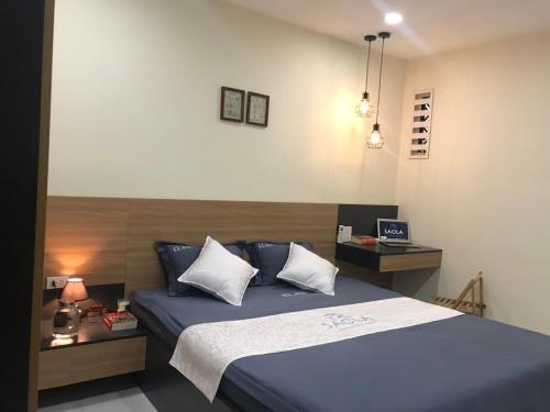 a bedroom with a blue bed and a desk at SAOLA Apartment FAMILY in Hai Phong