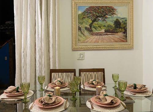 a dining room table with chairs and a painting on the wall at Casa azul Ilha Grande in Abraão