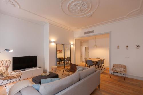 een woonkamer met een bank en een tv bij FLH Bacalhoeiros Spacious Apartment in Lissabon