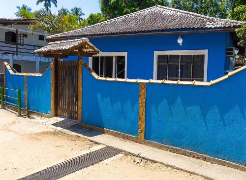 a blue house with a gate and a blue wall at Casa azul Ilha Grande in Abraão