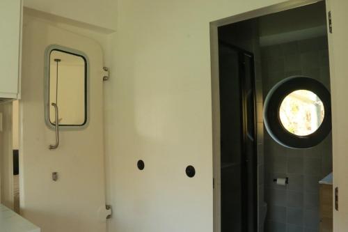 a bathroom with a door with a round window at Studio très cosy - indépendant dans une péniche - Paris 16 in Puteaux