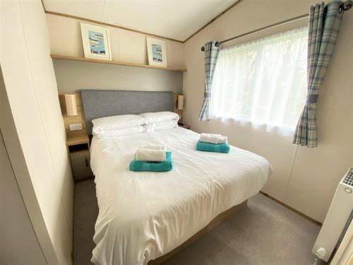 a bedroom with a bed with two towels on it at Bellevue in South Cerney