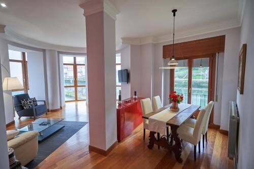 comedor y sala de estar con mesa y sillas en Apartamento BIO Exclusivo con mirador en Bilbao y aparcamiento público gratuito en Bilbao