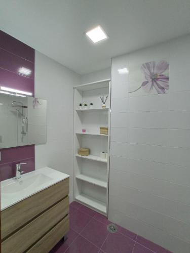 a white bathroom with a sink and a shower at Night Day Dúplex in Padrón