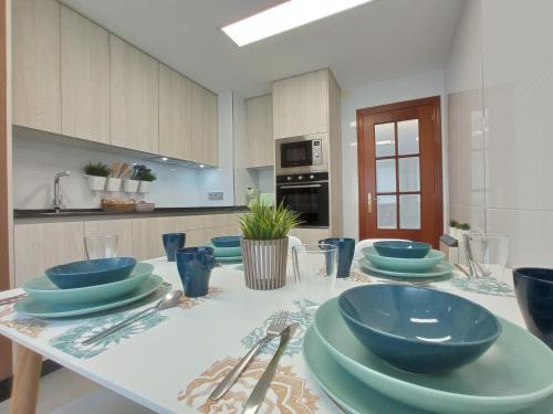 a kitchen with a table with blue dishes on it at Martínez Padrón Dúplex in Padrón