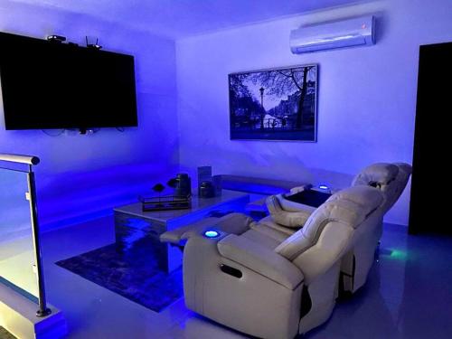 a living room with two white couches and a tv at Spectacular PentHouse with private jacuzzi terrace in Santiago de los Caballeros