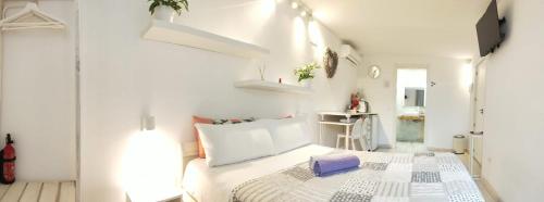 a white bedroom with a bed in a room at Dudi's Peppers in Málaga