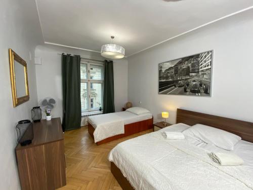 a hotel room with two beds and a window at P&J Apartments Floriańska in Krakow
