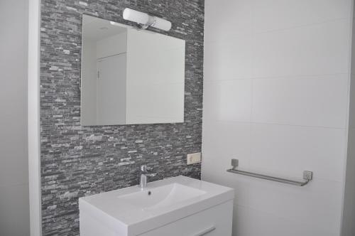 a bathroom with a white sink and a mirror at De Snip in Callantsoog
