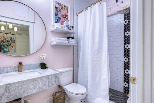 a bathroom with a toilet and a sink and a mirror at The Oleander Hotel Room Number 3 in Galveston