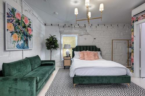 1 dormitorio con 1 cama y 1 sofá verde en The Oleander Hotel Room Number 3 en Galveston