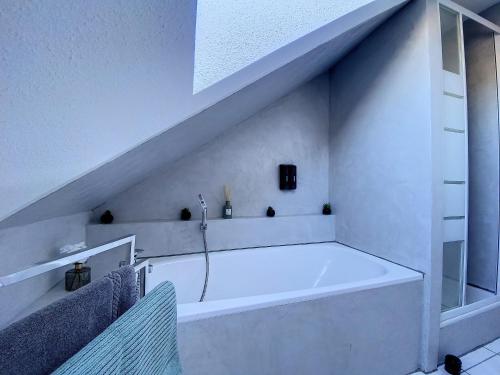 Baño blanco con bañera bajo una escalera en Chez Nat&Mat- Colmar gare- Parking gratuit, en Colmar