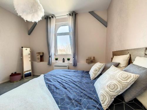 Un dormitorio con una cama azul y una ventana en Chez Nat&Mat- Colmar gare- Parking gratuit en Colmar