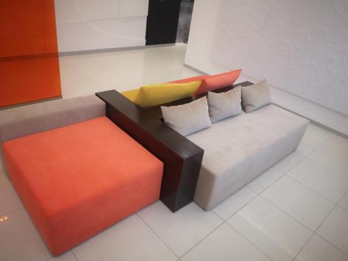 a couch with colorful pillows sitting in a room at Ayhan Hotel in Aktobe