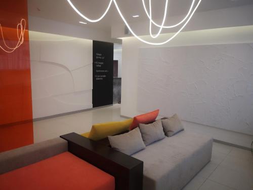 a couch with colorful pillows sitting in a room at Ayhan Hotel in Aktobe