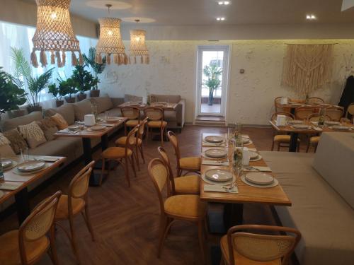 a dining room with tables and chairs and chandeliers at Ayhan Hotel in Aktobe