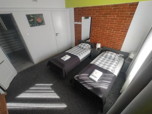 a room with two beds and a brick wall at RJ Hotel in Pabianice