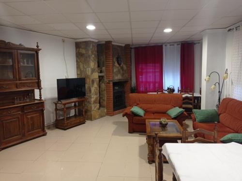uma sala de estar com dois sofás e uma televisão em Hostal Cañamares em Cañamares
