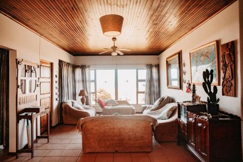 a living room with a couch and a ceiling at Bluefish Gully Inn in Kiddʼs Beach