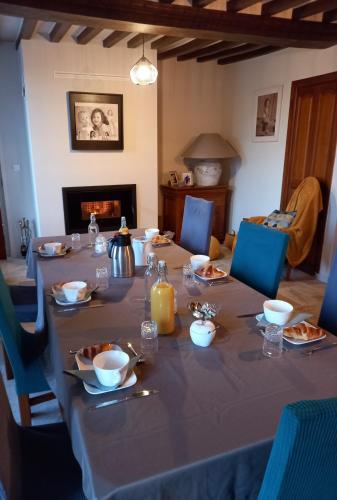 a table set for a meal in a room with a fireplace at Ferme du Rupalley in Isigny-sur-Mer