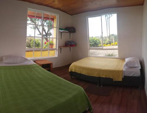 a bedroom with two beds and a window at Alojamiento EL GITANO in Filandia