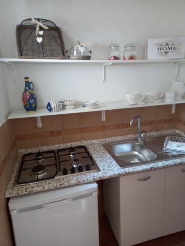 a kitchen with a sink and a stove top oven at Sole e mare in San Felice Circeo