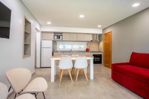 a kitchen with a table and chairs and a red couch at Mizu Hotel Boutique in Mar de las Pampas