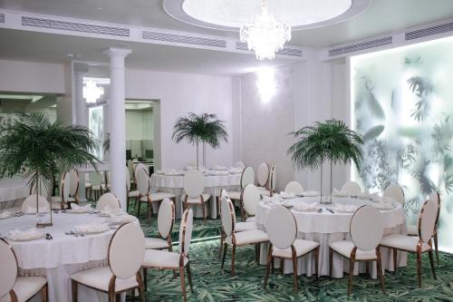 a conference room with tables and chairs and a chandelier at Hotel Relax Craiova in Craiova