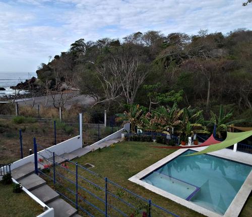 un patio trasero con piscina y hamaca en La Leona 1, en El Zonte