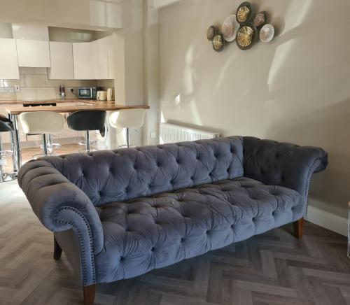 a blue couch sitting in a living room at Kinsale town cosy home 2 min walk to town center in Kinsale