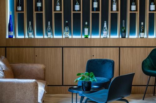 a room with a chair and a table and wine bottles at Hôtel Tandem - Boutique Hôtel in Strasbourg