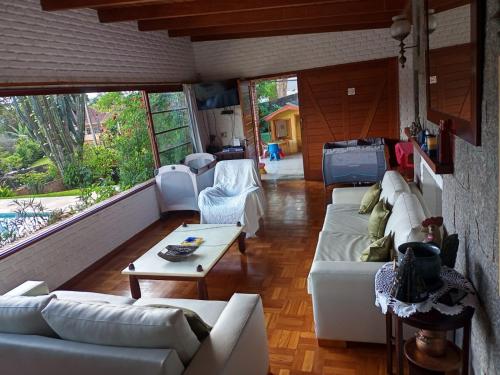 a living room with white couches and a table at Sítio N#1 da Serra Perfeito para famílias com bebês e crianças Piscina aquecida e limpeza incluídos in Teresópolis