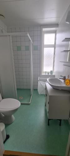 a bathroom with a toilet and a sink and a tub at Central lägenhet med gratis parkering in Lindesberg