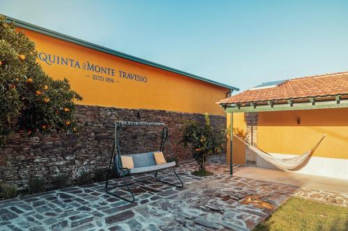 um pátio com uma rede de descanso em frente a um edifício em Quinta do Monte Travesso - Country Houses & Winery em Tabuaço