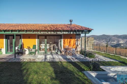 a house with a patio and a yard at Quinta do Monte Travesso - Country Houses & Winery in Tabuaço