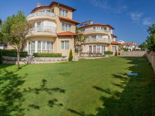 a large house with a lawn in front of it at Complex Pika in Golden Sands