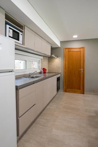 a kitchen with a sink and a wooden door at Mizu Hotel Boutique in Mar de las Pampas