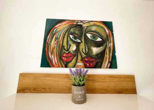 a painting of two women on a shelf with a flower at Sea View Apartment Amaro in Korčula