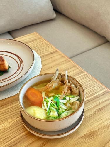 a bowl of soup with meat and vegetables on a table at Ayhan Hotel in Aktobe