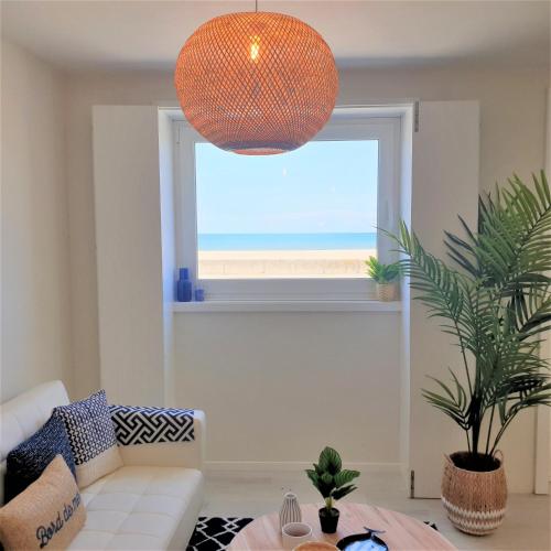 a living room with an ocean view from a window at The Shore @ Atlantic Beach - Waterfront Beach House, Tiny Pool, Terrasse in Espinho