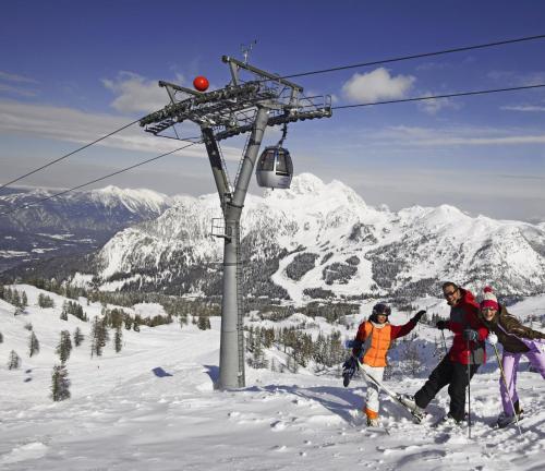 a group of people standing on a ski lift in the snow at Pension Leyrer in Kötschach