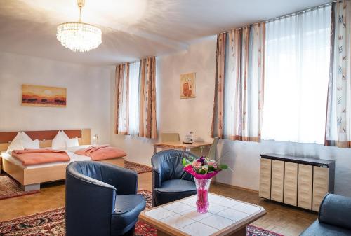 a hotel room with a bed and a vase of flowers on a table at Pension Dr. Geissler in Vienna