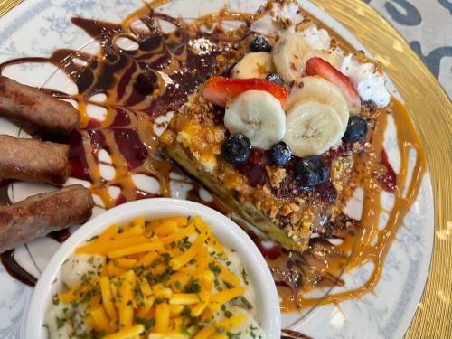 a plate of breakfast food with waffles and fruit and sauce at Peace & Plenty Inn Bed and Breakfast Downtown St Augustine-Adults Only in Saint Augustine