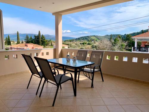 a table and chairs on a balcony with a view at Rosa’s Apartments in Lefkada Town