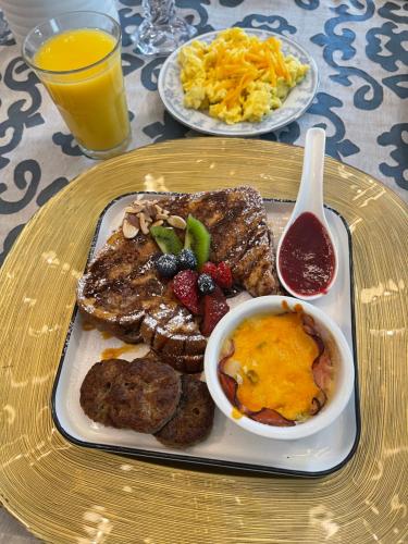 a plate of breakfast food with french toast and scrambled eggs at Peace & Plenty Inn Bed and Breakfast Downtown St Augustine-Adults Only in Saint Augustine