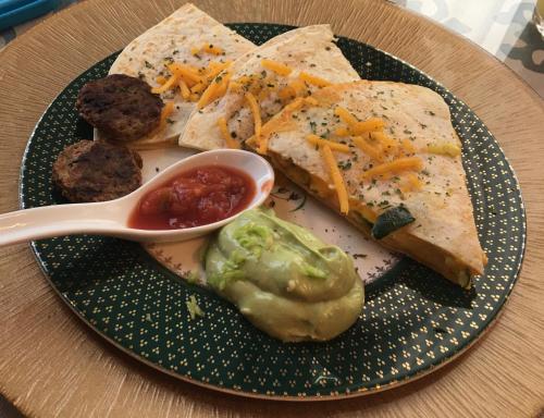 a plate of food with bread and cheese and a spoon at Peace & Plenty Inn Bed and Breakfast Downtown St Augustine-Adults Only in Saint Augustine