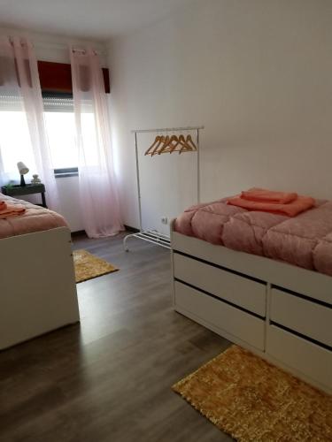 a bedroom with two beds and rugs in it at Casa da Avó Bé in Portalegre