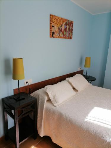 um quarto com uma cama e duas mesas com candeeiros em capricho 2 asturias COLOMBRES em Ribadedeva