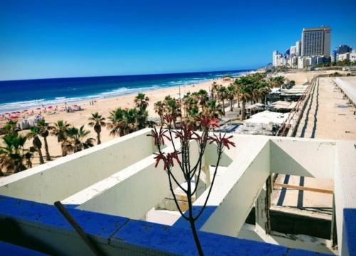 a view of the beach from the balcony of a resort at Hotel Apartment Short Term Tel Aviv Bat Yam 5 in Bat Yam
